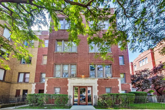 Front view of a multi-story brick apartment building.