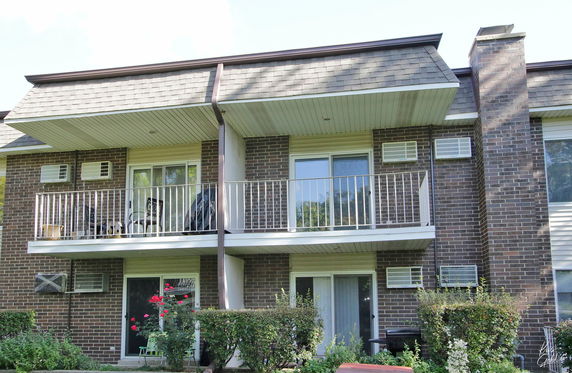 Front view of a two-story brick residential building with balconies.