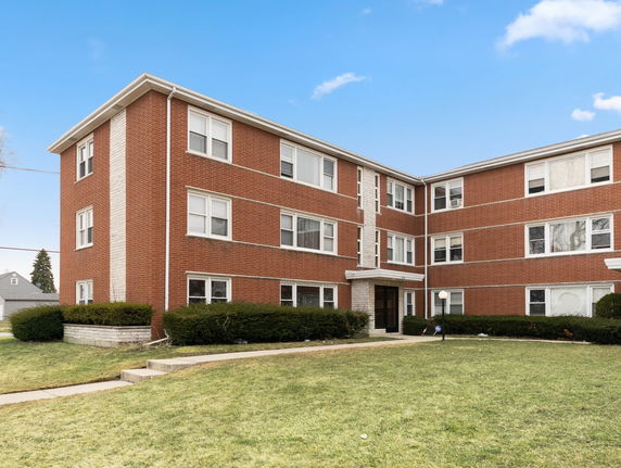 Front view of a three-story brick apartment building.