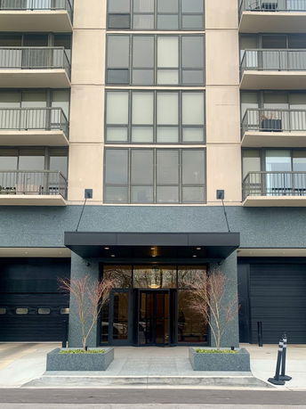 Front view of a multi-story building with balconies and an entrance.