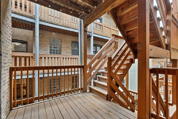Outdoor wooden staircase and railing of an apartment building.