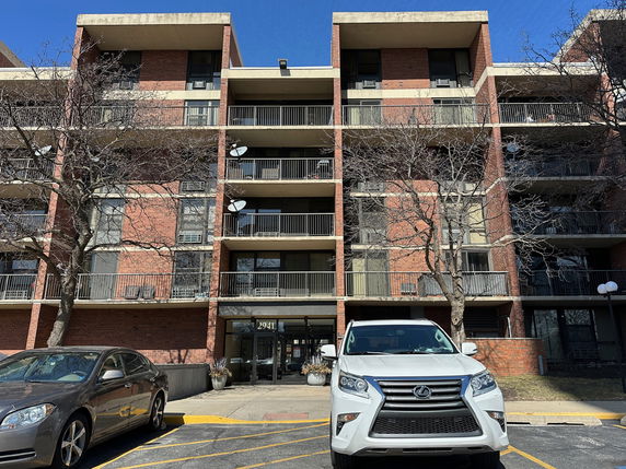 Front view of a multi-story apartment building with balconies.