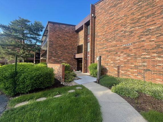 Front view of a brick apartment building with multiple floors.