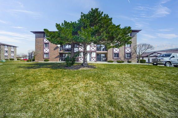 Front view of a multi-story residential building with brick facade and balconies.