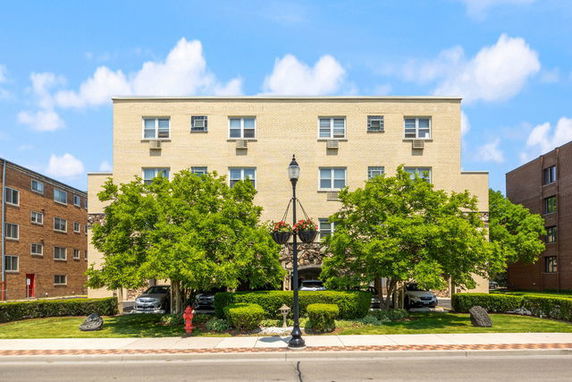Front view of a multi-story building with symmetrical windows and a central entrance.