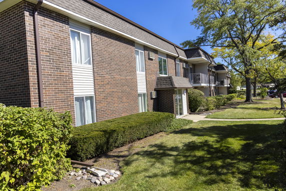 Front view of a multi-story residential building with brick facade and balconies.