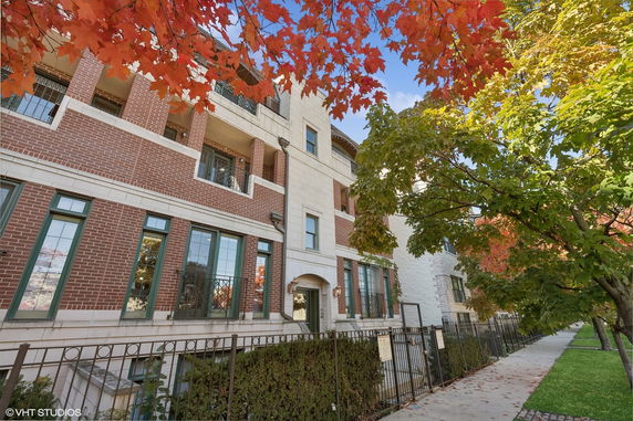 Front view of a multi-story brick and stone building with balconies.