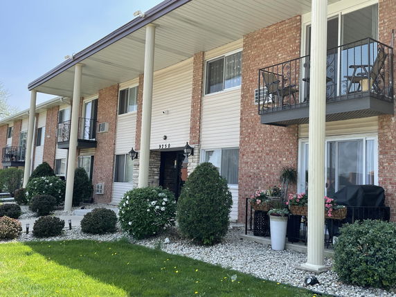 Front view of a two-story building with balconies and brick exterior.