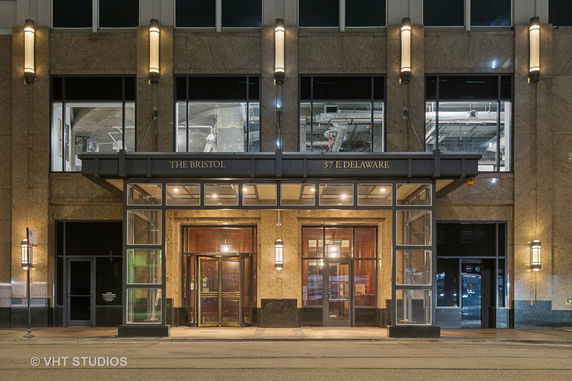 Front view of a building entrance with glass and stone facade.