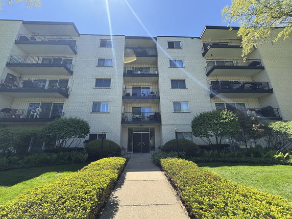 Front view of a multi-story residential building with balconies.
