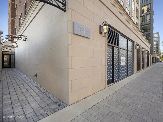 Side view of a multi-story building with decorative wall lamps and patterned window coverings.