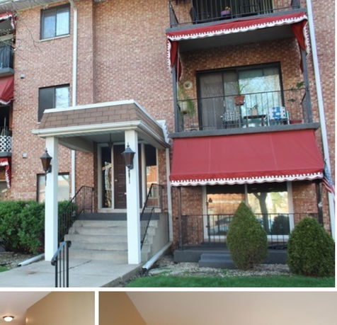 Front view of a multi-story brick building with balconies and awnings.