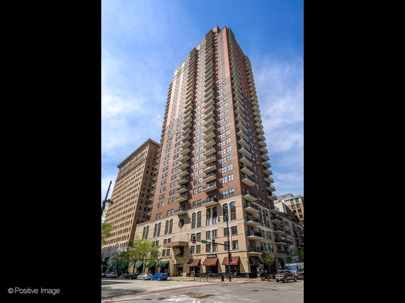 Front view of a tall multi-story apartment building with numerous balconies.