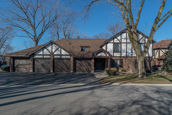 Front view of a multi-story house with gabled roof and attached garage.