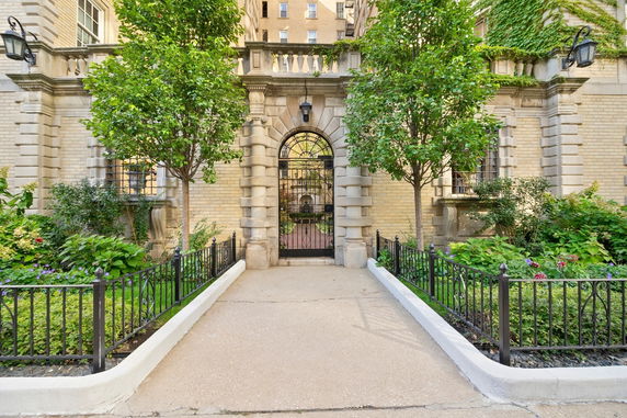 Front view of an ornate brick building with a gated entrance.