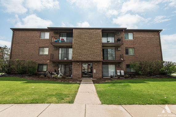 Front view of a multi-story brick building with balconies.