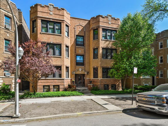 Front view of a multi-story brick building with symmetrical design and large windows.
