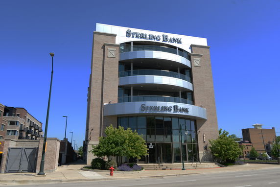 Front view of a multi-story bank building with large glass windows and signage.