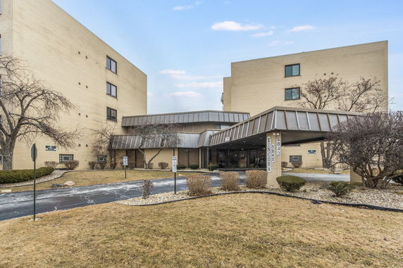 Front view of a multi-story building with a covered entrance.