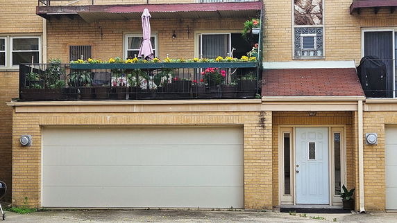 Front view of a two-story house with a balcony and double garage.