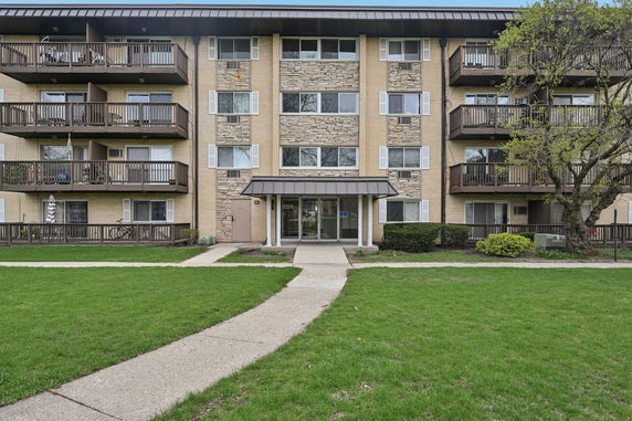Front view of a multi-story apartment building with balconies.