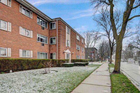 Front view of a multi-story brick apartment building.