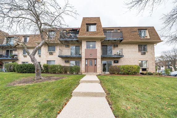 Front view of a multi-story apartment building with balconies.