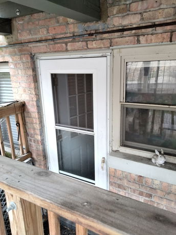Exterior view of a brick wall with a door and window.