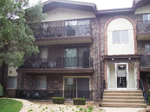 Front view of a multi-story apartment building with balconies.