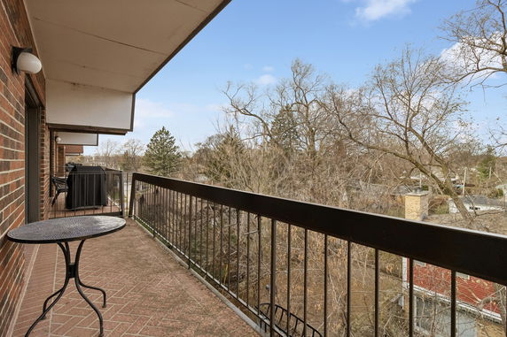 Balcony view overlooking trees and rooftops.
