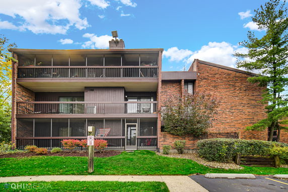 Front view of a multi-story brick building with balconies.