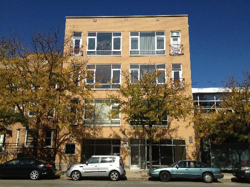 Front view of a multi-story building with large windows.