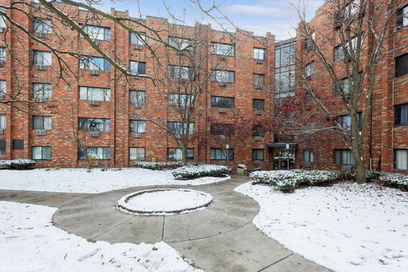 Front view of a multi-story brick apartment building.