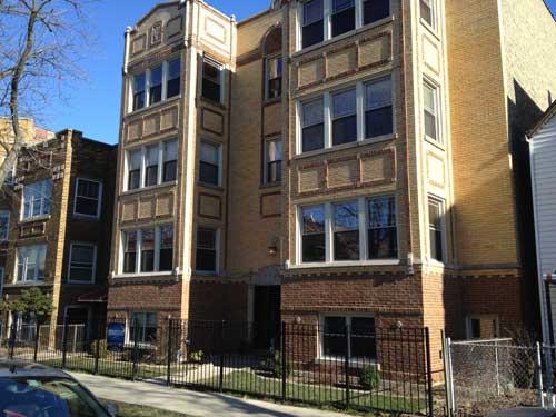 Front view of a multi-story brick apartment building.
