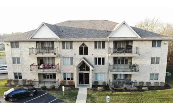 Front view of a three-story apartment building with balconies.