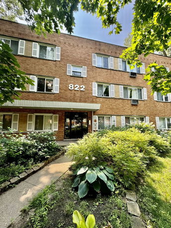 Front view of a three-story brick building with multiple windows.