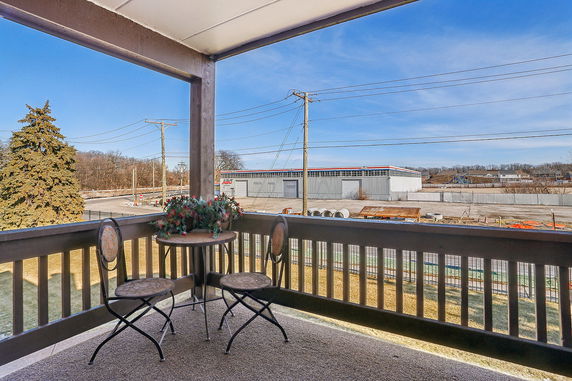 View from a balcony showing surrounding industrial area with a small table and chairs.