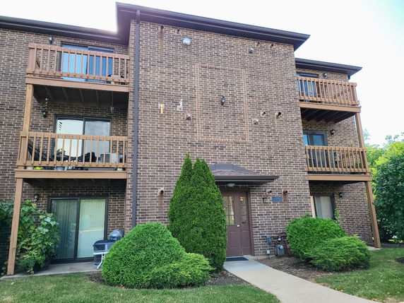 Front view of a multi-story brick building with balconies.