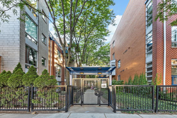 Front view of a residential building with a gated entrance and modern architecture.