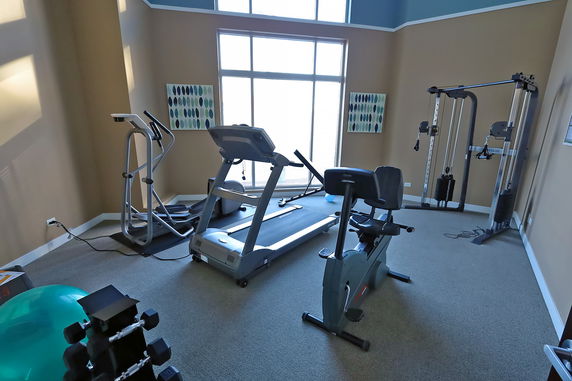 Indoor gym area with exercise equipment including treadmill, elliptical, and stationary bike.