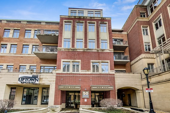 Front view of a multi-story building with brick facade and balconies.