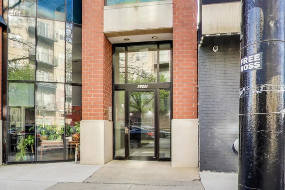 Entrance view of a building with glass doors and brick facade.