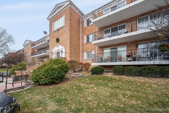 Front view of a multi-story brick building with balconies.