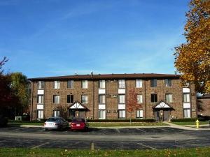 Front view of a three-story brick apartment building with multiple entrances.