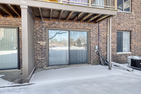 Exterior view of a building with brick facade and sliding glass door.