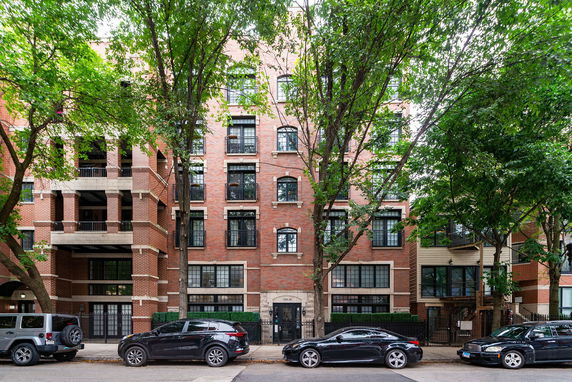 Front view of a multi-story brick building with large windows.