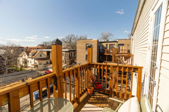 View from a wooden deck or balcony overlooking neighboring houses and buildings.