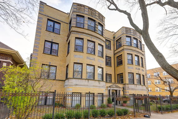 Front view of a multi-story brick apartment building with decorative window designs.