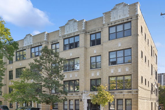 Front view of a four-story brick apartment building.