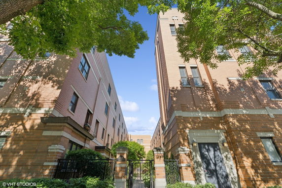 Front view of a multi-story brick building with gated entrance.
